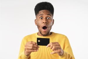 Shocked young man holding credit card